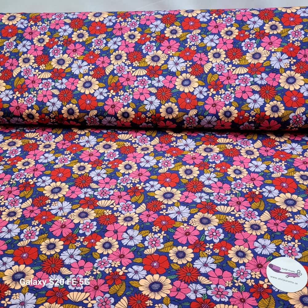 Mönstrat Trikåtyg Jona med blommor på blå botten